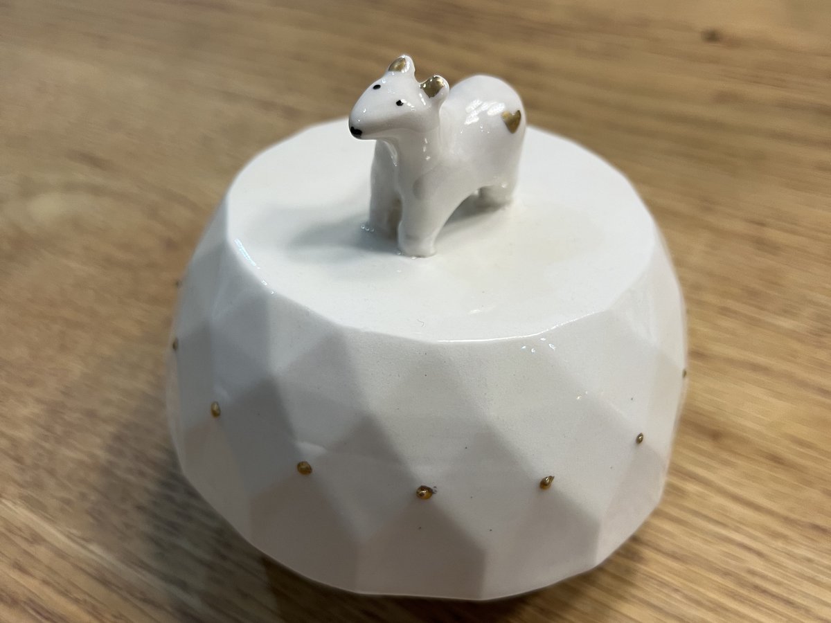 Boîte à musique de naissance en porcelaine blanche facettée, surmontée d'une figurine d'ourson et ornée de pois d'or