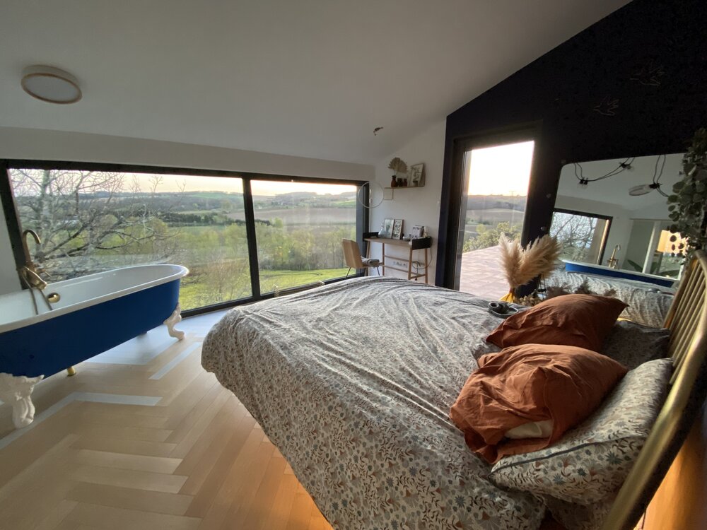 Une chambre cocon avec baignoire et vue sur la campagne