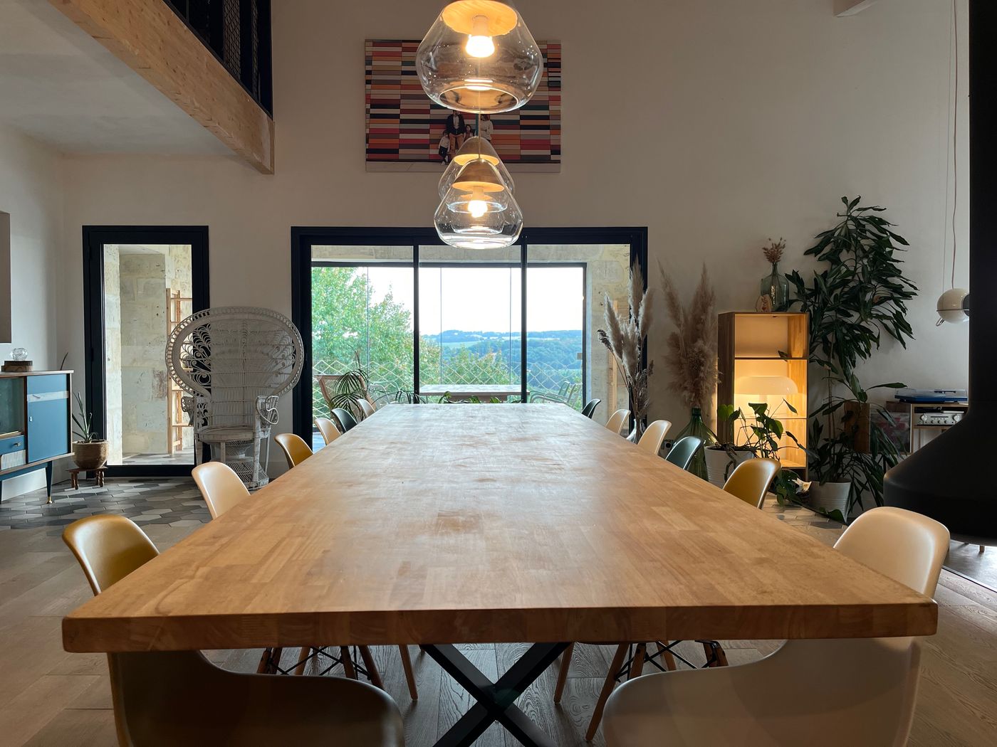 La grande table en bois face à la baie vitrée, prête pour l'atelier
