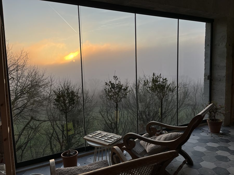La véranda vitrée au lever du jour, la vallée encore dans la brume